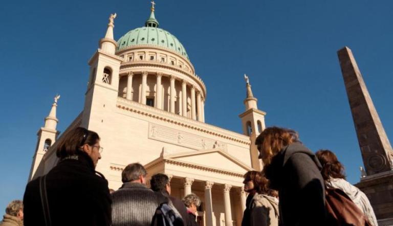 Nikolaikirche schräg von unten fotografiert mit Menschen im Vordergrund