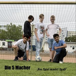 Die 5 Macher - "Das Spiel macht Spaß!" Fünf Jungs posieren als Fussballer mit Ball in einem Fußballtor.