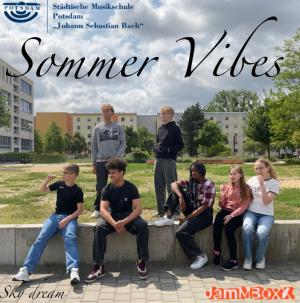7 Jugendliche chillen auf einem Mäuerchen vor einer Wiese. Einige haben Eis am Stil.