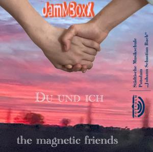 Wir sehen zwei Unterarme und zwei Hände, die einander halten. Im Hintergrund ein Sonnenuntergang - aufgenommenen aus einem Fahrzeug während der Fahrt.