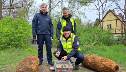 Dr. Karsten Lauber, Mike Schwitzke und Kai Lange mit den beiden entschärften Fliegerbomben am 23. April 2026