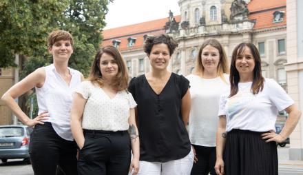 Die Teammitglieder des Büros für Chancengleichheit und Vielfalt der Landeshauptstadt Potsdam stehen auf der anderen Straßenseite vom alten Rathaus, in der Friedrich-Ebert-Straße 79/81, das alte Rathaus ist im Hintergrund zu sehen (von links nach rechts: Ina Bellmann, Claudia Sprengel, Dr. Tina Denninger, Dr. Amanda Palenberg, Stefanie Buhr)