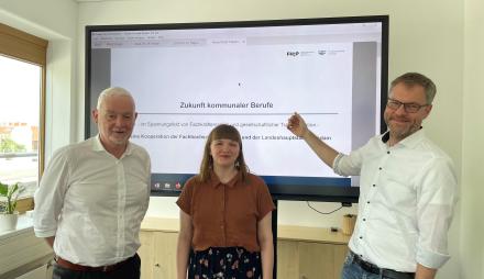 Mitarbeitende der Fachhochschule sowie der Stadt Potsdam stellen vor einem Bildschirm ihr Projekt vor.