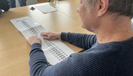Ein Mann wählt mit der Schablone bei der Bundestagswahl