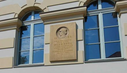 Plakette aus Sandstein an der Dortuschule mit der Innschrift "1848 Hier wurde geboren am 29. Juni 1826 Max Dortu Kämpfer und Opfer für Deutschlands Einheit und Freiheit. Standesrechtlich erschossen am 31. Juli 1849.
