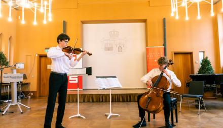 Zwei Jugendliche spielen Violine und Violoncello.