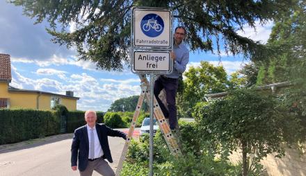 Bernd Rubelt (links) und Torsten von Einem (rechts auf einer Leiter stehend) an der neuen Fahrradzone.