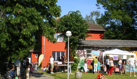 Das Groß Glienicker Begegnungshaus bei einem Fest, an dem viele Menschen vor dem Haus sind.