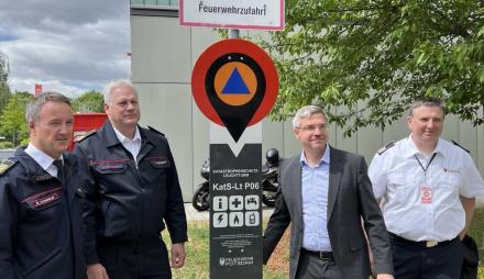 Oberbürgermeister Mike Schubert und drei weitere Männer stehen neben einem Katastrophenschutz-Leuchtturm.