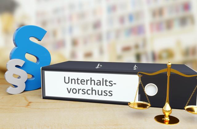 Unterhaltsvorschuss Begleitendes Bild zum Thema Unterhaltsvorschuss: Ein Aktenordner mit der Bezeichnung Unterhaltsvorschuss liegt neben Paragraphensymbolen und einer Waage