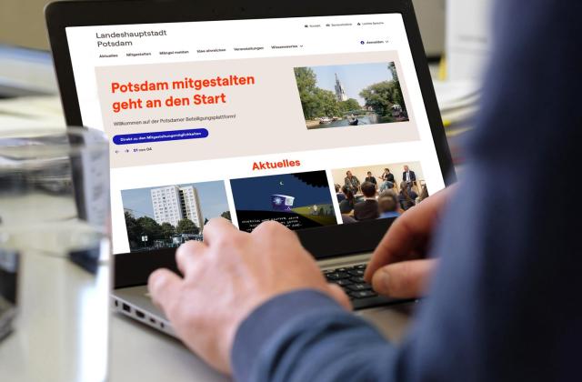 Notebook mit der Startseite von mitgestalten.potsdam.de, an dem eine Person arbeitet.