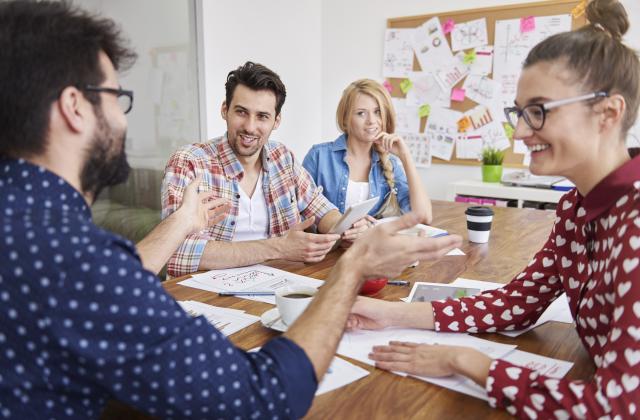 Vier Personen sitzen an einem Tisch in Workshop-FOrm.