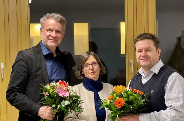 In der Mitte des Sprecherduos vom Fachgremium Erinnerungskultur, Dr. Peter Ulrich Weiß und Markus Wicke - beide mit einem Blumenstrauß, steht Heike Bojunga, Leiterin des Fachbereichs Kommunikation und Partizipation.