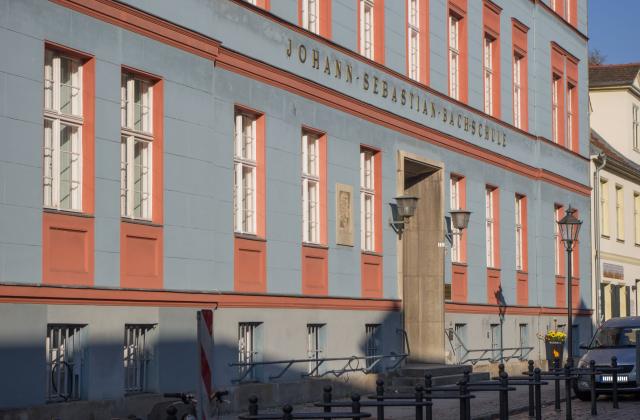 Die Musikschule hat ihren Sitz in der Jägerstraße. Auf der blau-roten Fassade ist der Schriftzug „Johann-Sebastian-Bach-Schule“ zu lesen. Links neben der Tür ist ein Portrait des Komponisten zu sehen.