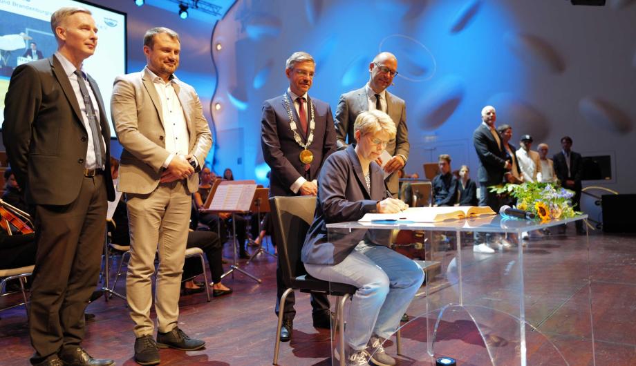 Katja Gluske trägt sich ins Goldene Buch der Stadt ein.