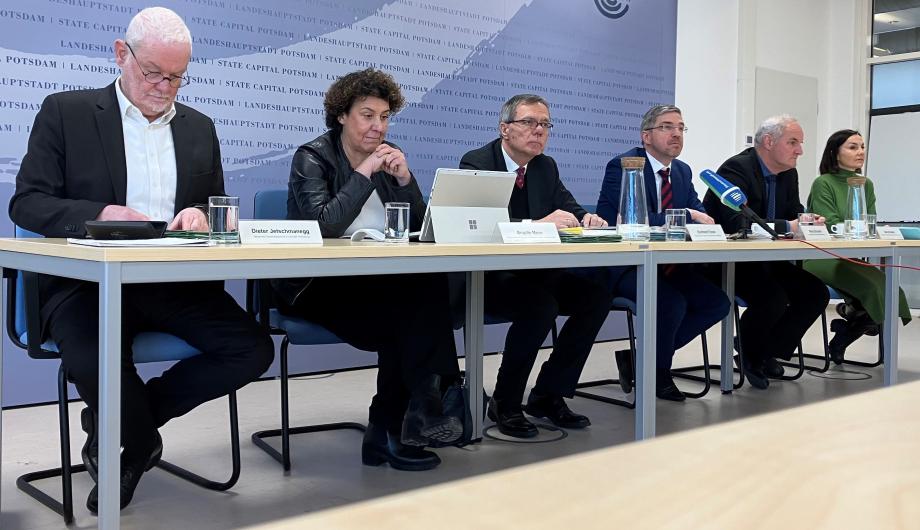 Die Beigeordneten und der Oberbürgermeister sitzen vor der Pressewand der Stadt und reden über den Haushalt 2025