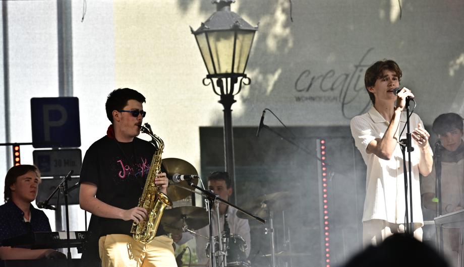 Eine Pop-Jazzband mit 5 jungen Männern performed auf einer Open-Air Bühne und zeigt dabei Gefühl