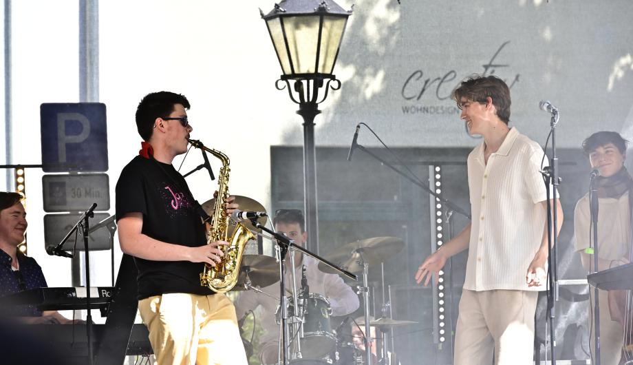 Eine Pop-Jazzband mit 5 jun gen Männern performed auf einer Open-Air Bühne und hat sichtlich Spass