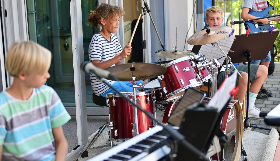 Action auf einer Terassenbühne - gebannt schaut der junge Bassist zur Schlagzeugerin, die ein Solo-Film spielt.