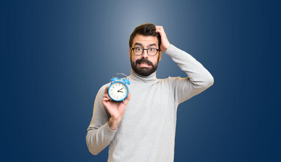 Keine Zeit aufs Amt zu kommen? Ein Mann unter Zeitdruck hält einen Wecker in der Hand.