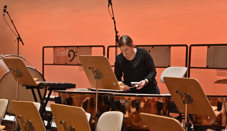 Paukenstimmen vor dem Konzert Eine junge Frau stimmt 4 Kesselpauken. Sie hält dazu ein Stimmgerät