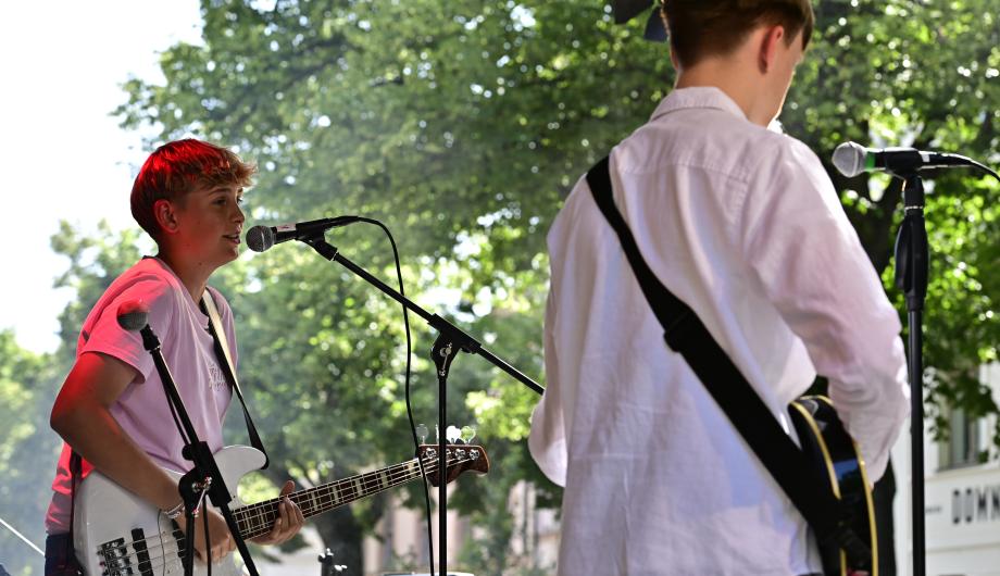 Zwei Jugendliche performen auf sonniger Bühne Musik
