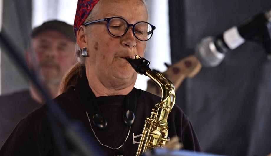 Wir sehen eine ältere Saxophonistin beim engagierten Auftritt