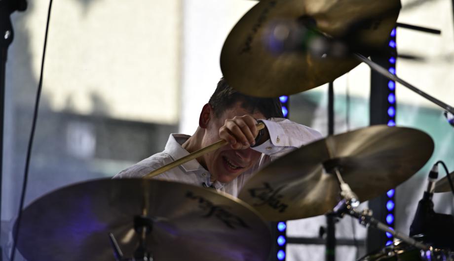 Ein Rockdrummer auf der Bühne wischt sich mit dem Ärmel über das Gesicht