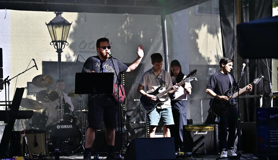 Eine Rockband mit 5 jungen Männern performed auf einer Open-Air Bühne und zeigt dabei Gefühl