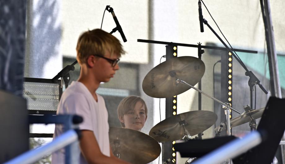 Wir sehen einen sehr jungen Drummer beim Auftritt