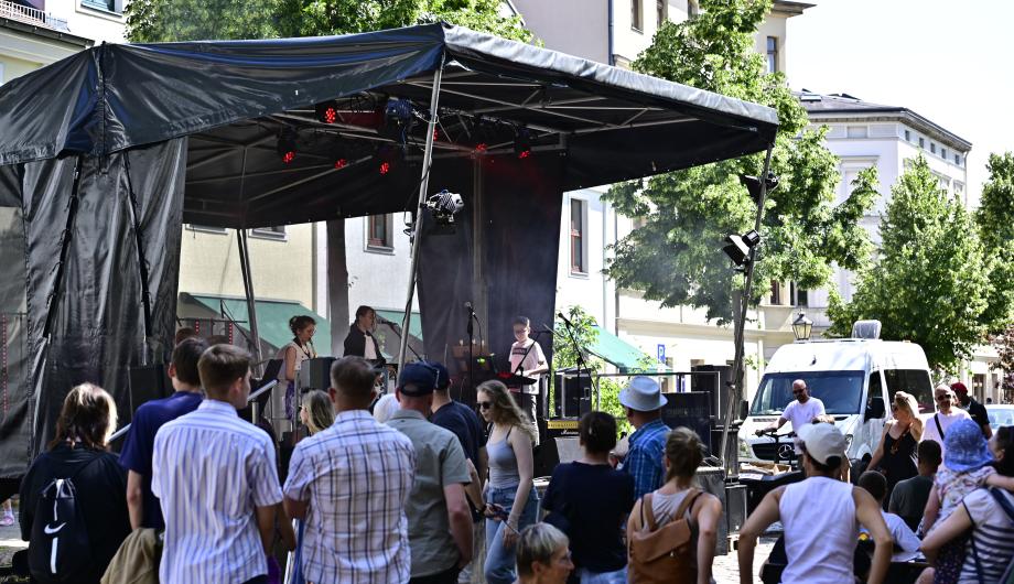Wir sehen eine sehr junge Band beim Open-Air Auftritt mit viel Publikum