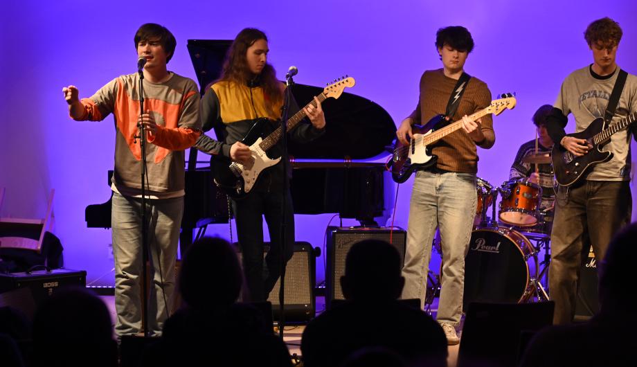 Auf einer lila leuchtenden Bühne im Kammermusiksaal der Städtischen Musikschule spielt die 5-köpfige Band The Solid Preachers Club