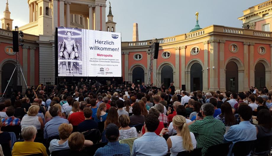 Das Deutsche Filmorchester Babelsberg begleitet die Aufführung des Stummfilmklassikers „Metropolis“ im Innenhof des Brandenburger Landtags. Die Wurzeln des 1993 neu gegründeten Orchesters reichen bis zum „UFA-Sinfonieorchester“ zurück, das 1918 von der Universum Film AG (UFA) in Babelsberg gegründet wurde, 2016 - The German Film Orchestra Babelsberg accompanies the screening of the silent film classic “Metropolis” in the courtyard of the Brandenburg parliament building. (© Agentur manitours,