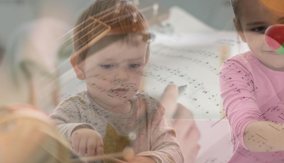 junge spielt auf Glockenspiel - Musiknoten schimmern durch das Bild