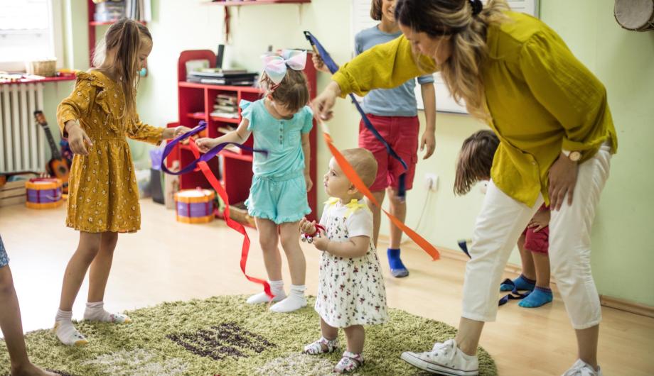 junge Kinder tanzen in Kita zu Musik