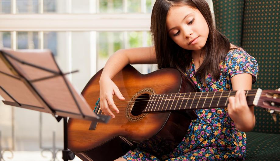 Junges Mädchen übt Gitarre