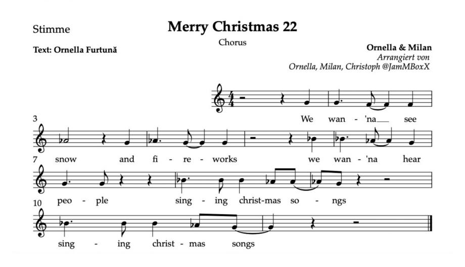 Zu sehen sind Musiknoten und ein Mitsingtext: {Chorus} We want to see snow and fireworks We want to see people singing Christmas songs, singing Christmas songs