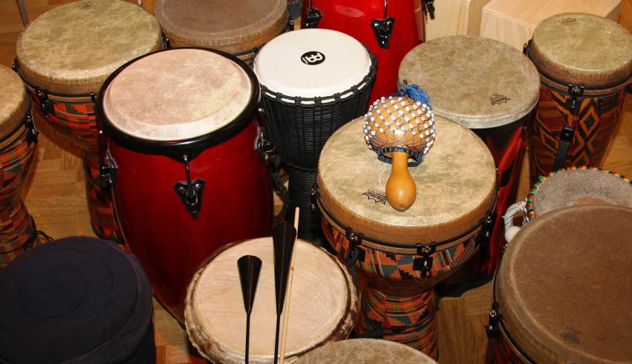Percussion (foto: pixabay) Auf diesem Bild sind mindestens zwölf Trommeln zu sehen. Sie kommen unter anderem aus Afrika und haben natürlich Felloberflächen. Auf zwei Trommeln sind zur Ansicht auch Rasseln und zwei miteinander verbundene Metallglocken namens Agogo bereitgelegt.