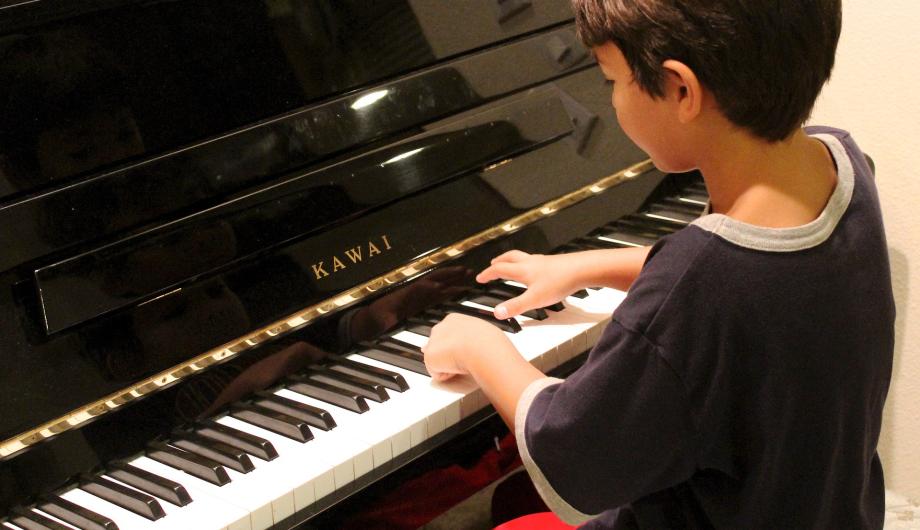 Ein Junge spielt Klavier.