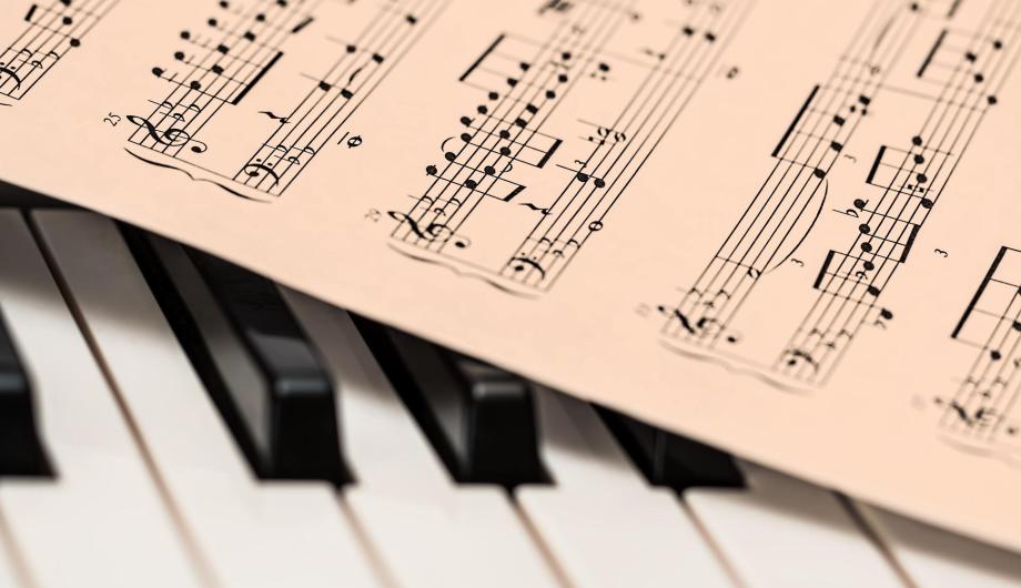 Auf diesem Stilleben sind Klaviertasten sowie eine Ecke eines Notenblattes zu sehen. Beides repräsentiert die Schönheit einer Klavierkompositione.