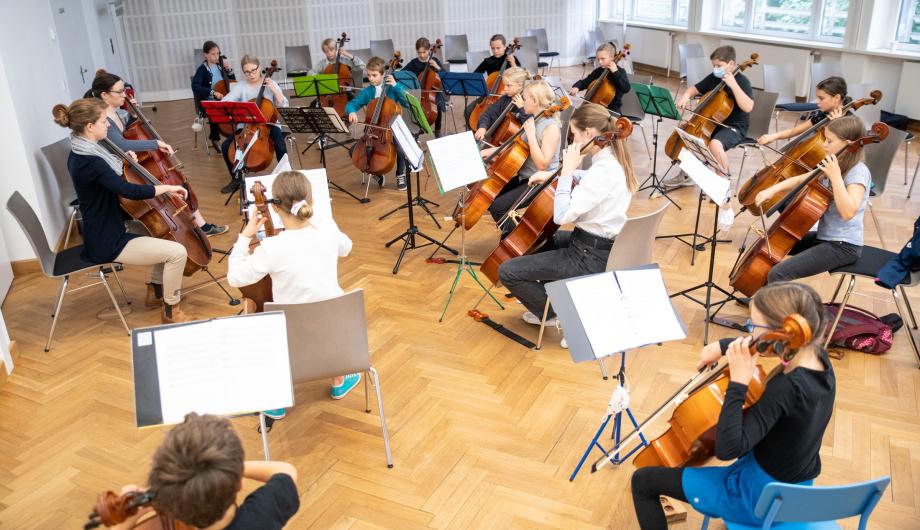 Viele junge Cellistinnen und Cellisten proben unter Anleitung erfahrener Dozentinnen