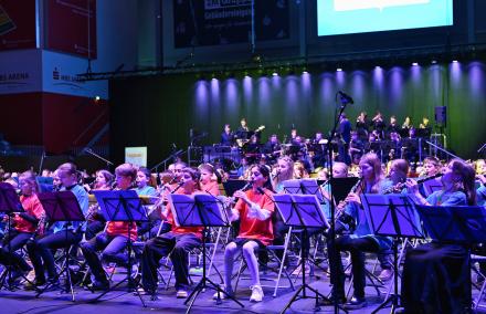Begeistertes Zusammenspiel! Begeistert spielen 250 Kinder mit Blasinstrumenten gemeinsam mit einer Jugendbigband in der Potsdam MBS-Arena