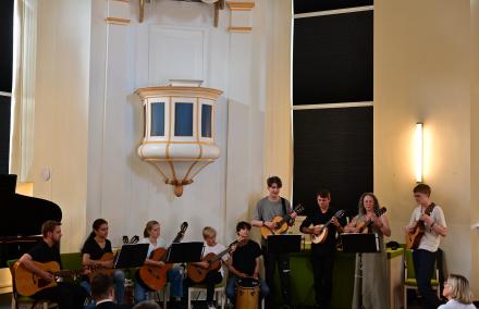 Die Zupfinstrumentengruppe LES BOUFFONS spielt in voller Größe in einem Pavillon, der einer Kapelle gleicht.
