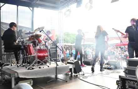 Solid Preachers Club rocken den Stern-Kiez Wir schauen von hinten auf einen Open Air Rock Bühne. Fünf junge erwachsene Männer performen als Rockband