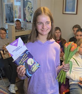 Marla Schmid aus der Katholischen Marienschule Das Foto Zeigt Marla Schmid aus der Katholischen Marienschule. Sie hält das Buch „Als die Welt uns gehörte“ in der Hand.