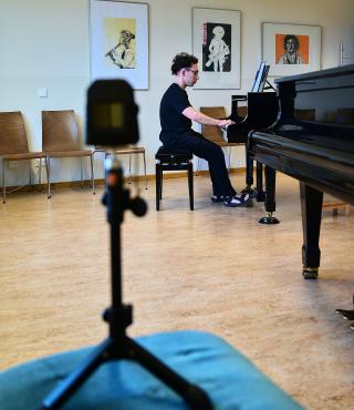 "Vexations" - in der Städtischen Musikschule Potsdamm - Standort Am Stern Im Vordergrund ein Video und Tonaufnahmegerät. Aufgezeichnet wird der im Hintergrund spielende Pianist an einem Flügel