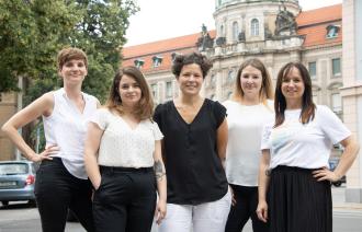 Die Teammitglieder des Büros für Chancengleichheit und Vielfalt der Landeshauptstadt Potsdam stehen auf der anderen Straßenseite vom alten Rathaus, in der Friedrich-Ebert-Straße 79/81, das alte Rathaus ist im Hintergrund zu sehen (von links nach rechts: Ina Bellmann, Claudia Sprengel, Dr. Tina Denninger, Dr. Amanda Palenberg, Stefanie Buhr)
