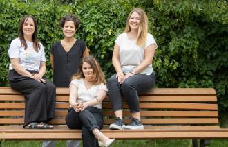 Die Beauftragten des Büros für Chancengleichheit und Vielfalt sitzen auf einer Bank.  (von links nach rechts: Stefanie Buhr, Dr. Tina Denninger, Claudia Sprengel, Dr. Amanda Palenberg)