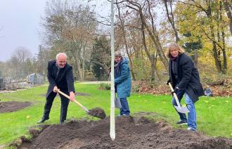 Bernd Rubelt und zwei Damen pflanzen einen Baum.
