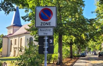 Ein Parkverbotszonen-Schild mit der Ausnahme, dass das Parken für Anwohnende mit den Parkausweisnummern 510 und 520 erlaubt ist